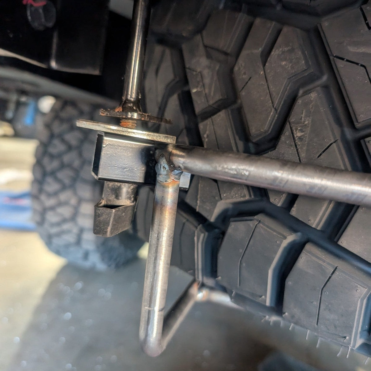 Cage arm attached to a vehicle beside a tire