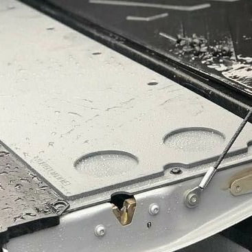 Close-up of the Mountain Hatch Hilux panel's drink holders with rain beading on the surface