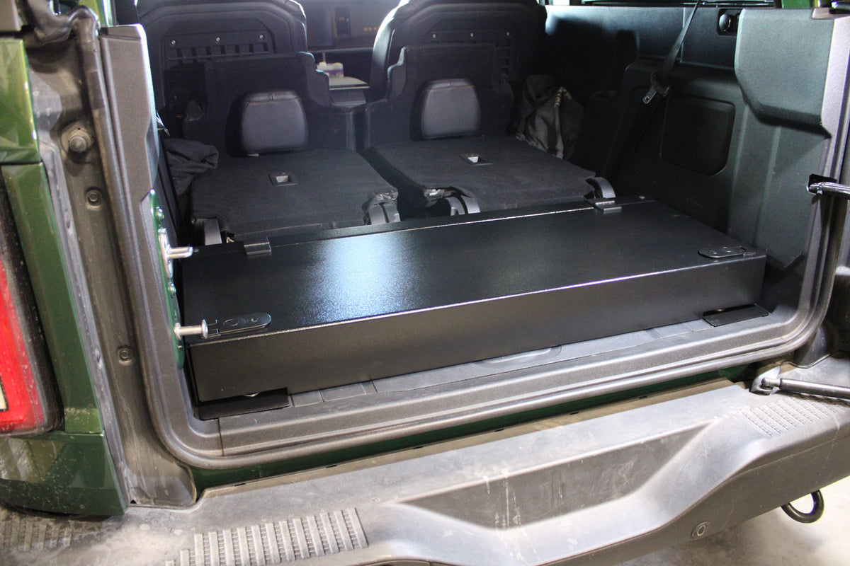 Stage platform behind the folded rear seats of a green Bronco