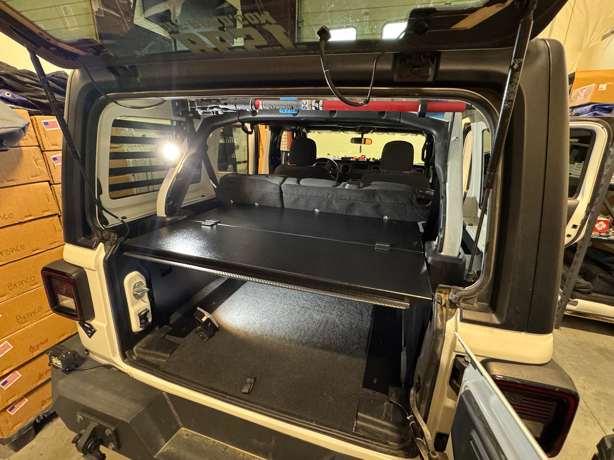 Ridgeback in a JLU with the top open, shop shelving behind