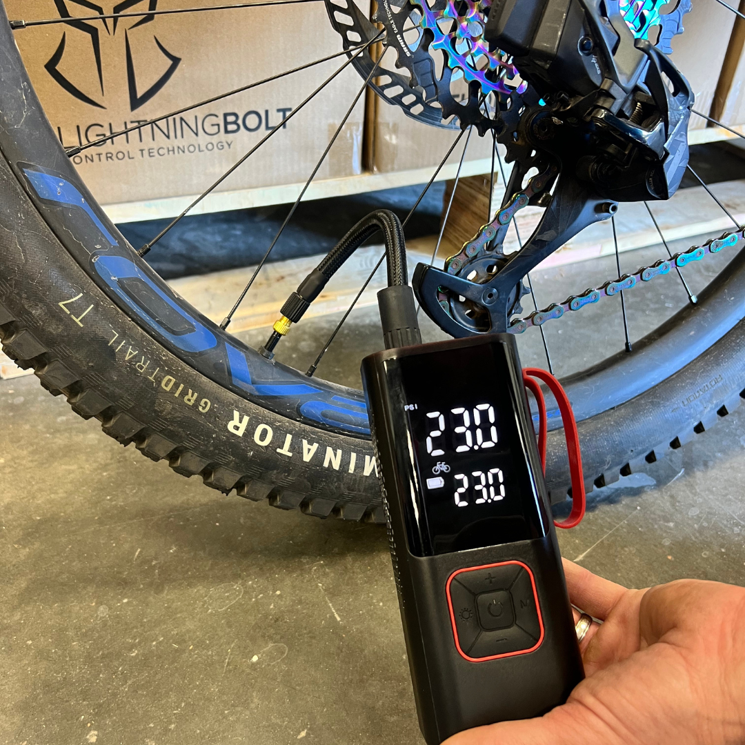 Lifestyle photo of the AirSpark compressor in use with the flexible hose extended