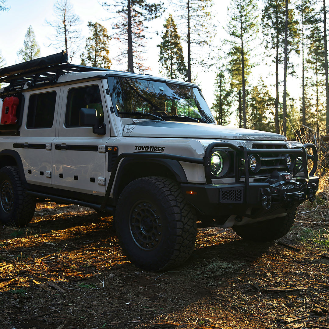 Silver SUV with a black bull bar on a forest trail