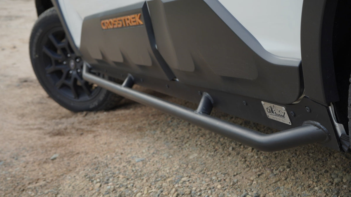 Rock slider tube running along the lower body on a dirt surface