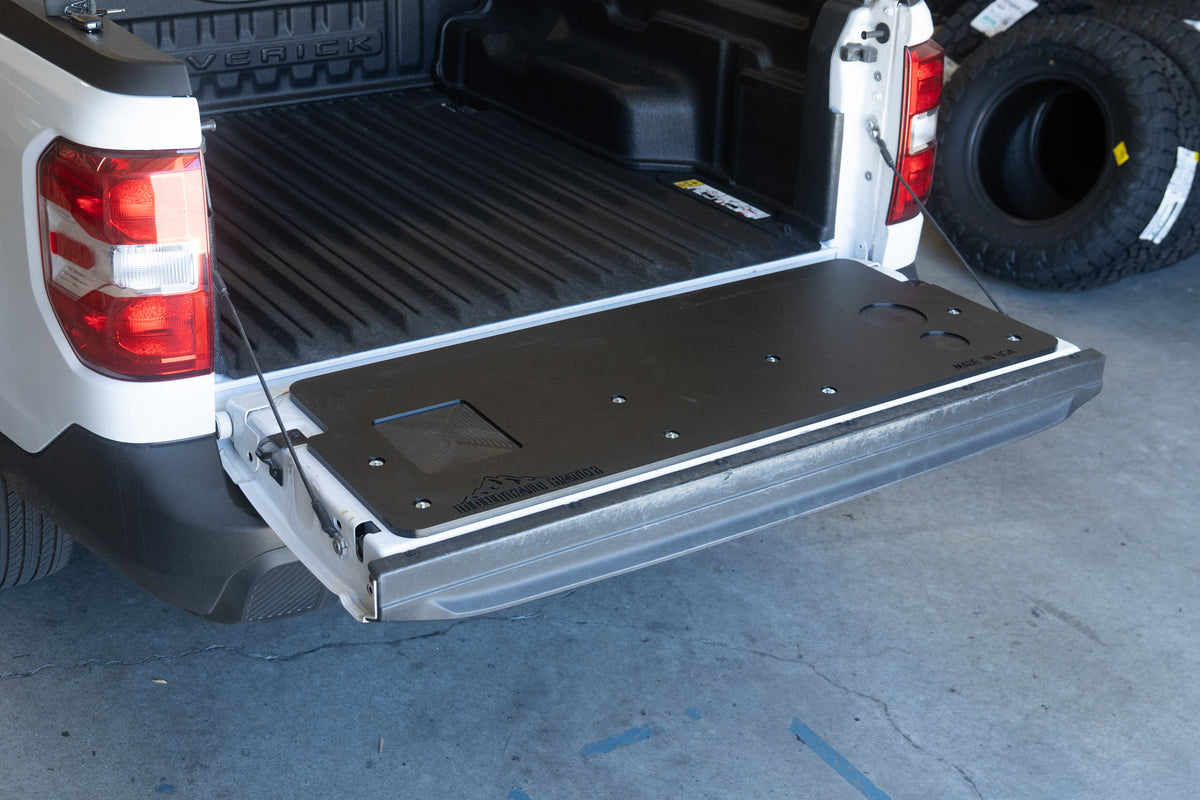 Mountain Hatch tailgate table on a 2022-2026 Ford Maverick, three-quarter view with the bed and spare tire behind