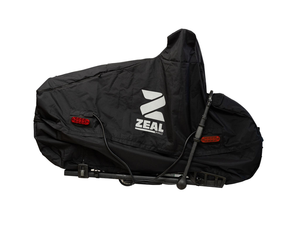 ZEAL Pro e-bike cover zipped closed on a tray hitch rack with Light Kit tail lights wired in