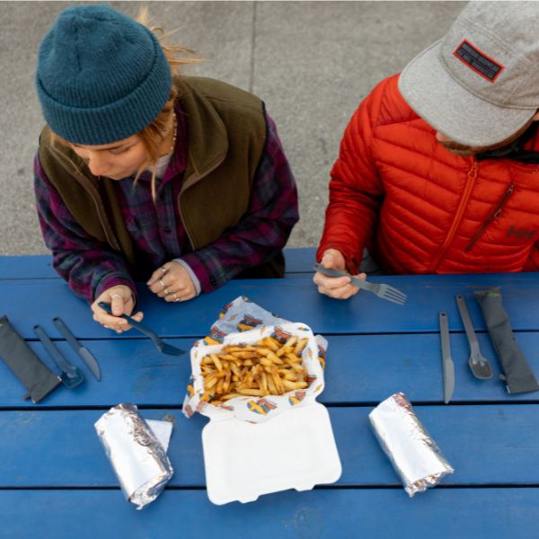 Man in a ballcap eating from a container using the UCO ECO utensils