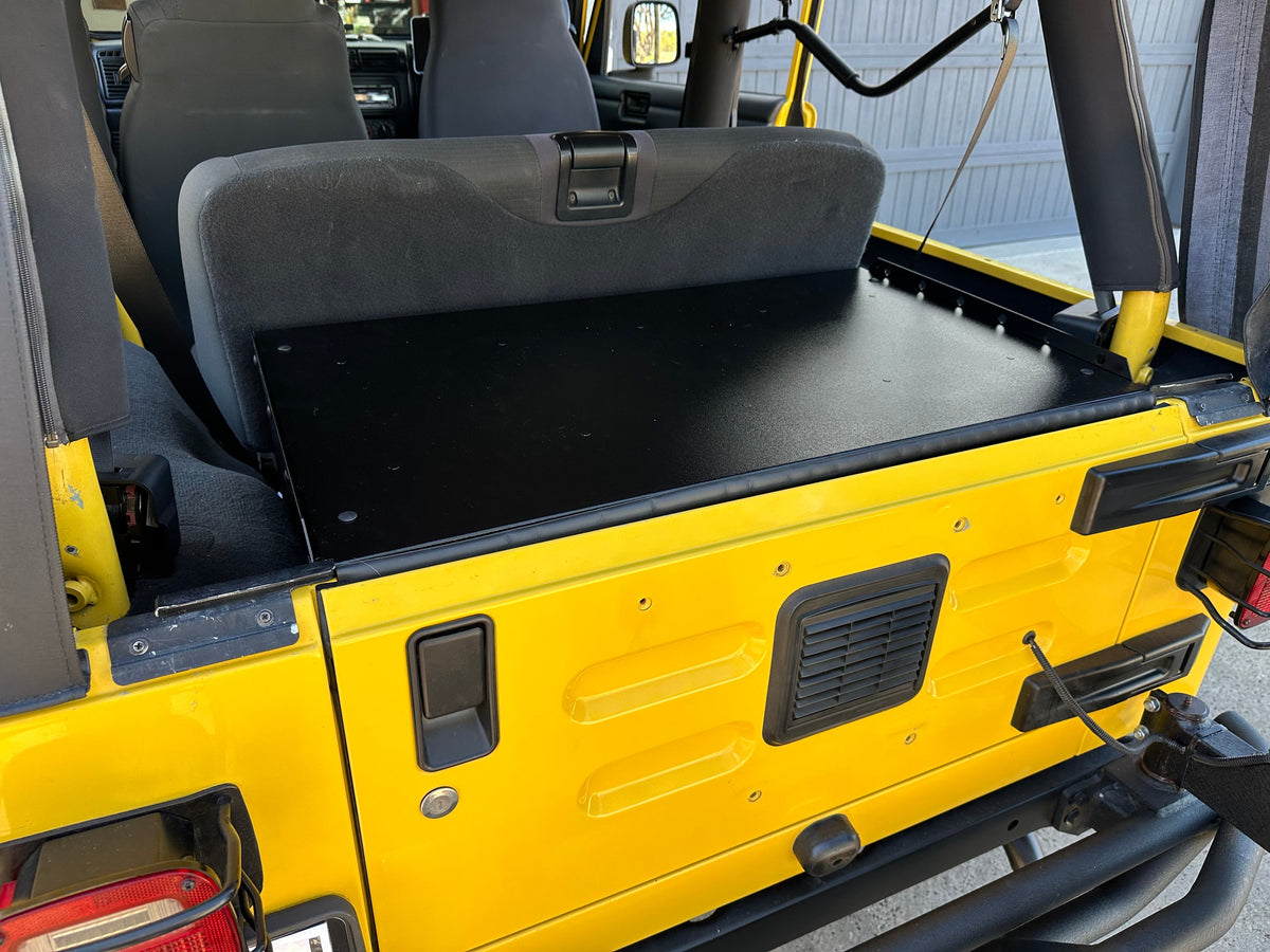 Ridgeback Basic installed behind the rear seat of a yellow Jeep LJ, tailgate open