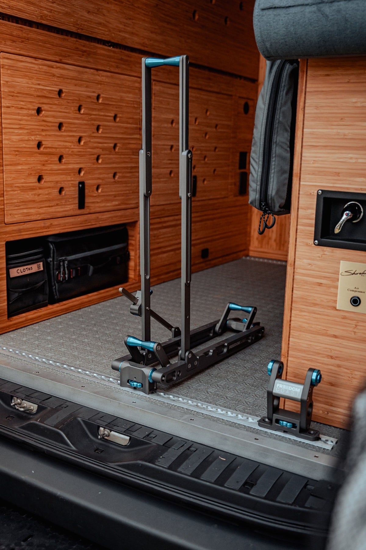 Empty HOVR rack upright on van floor track next to cabinetry