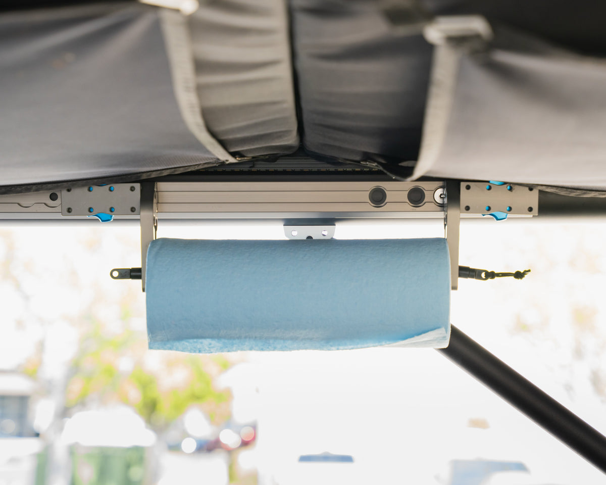 Front view of the paper towel holder hanging from camper L-track