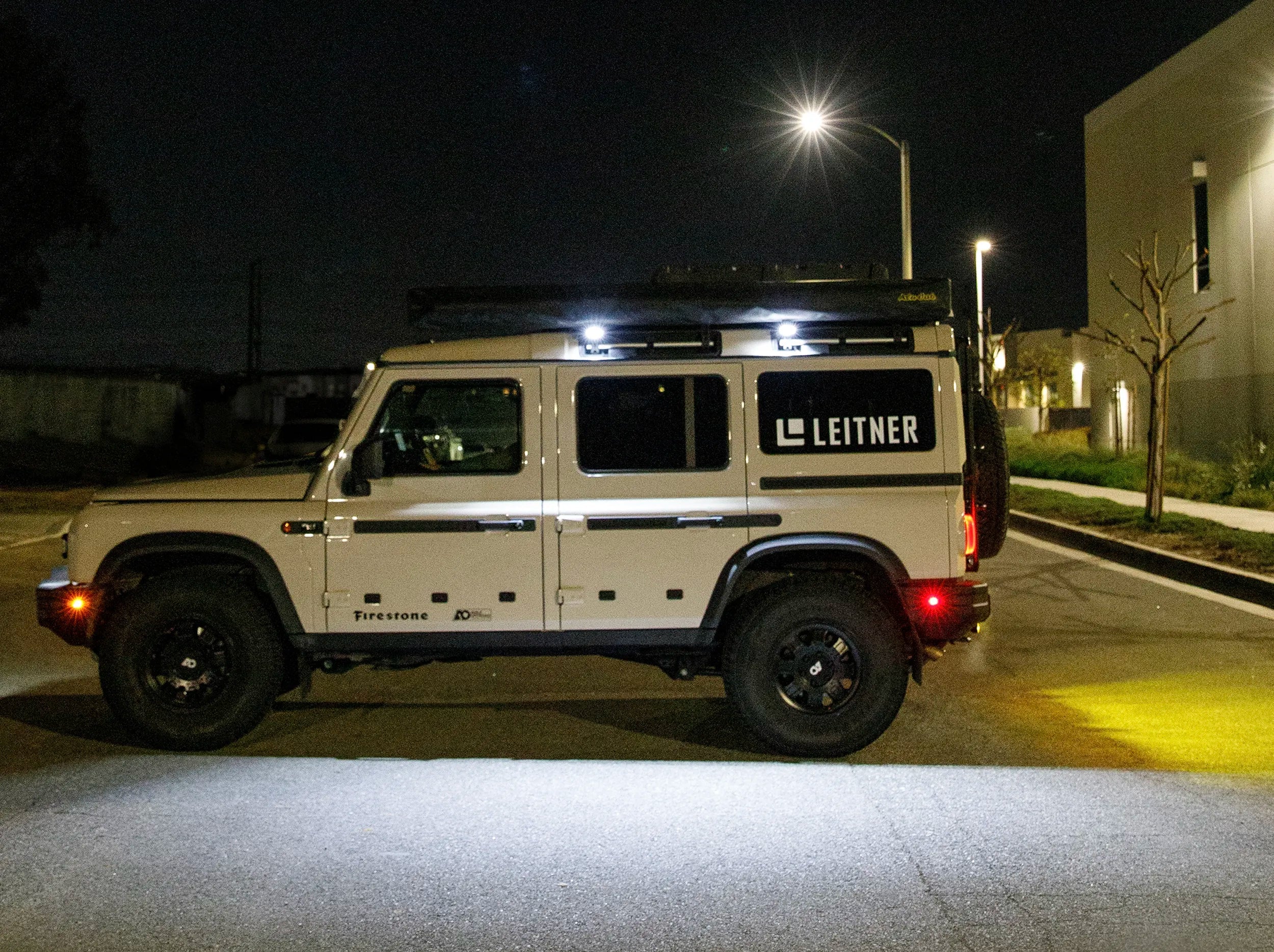 SIDE VIEW OF GRENADIER OUT AT NIGHT WITH LIT CHASE LIGHTS MOUNTED ON REAR 