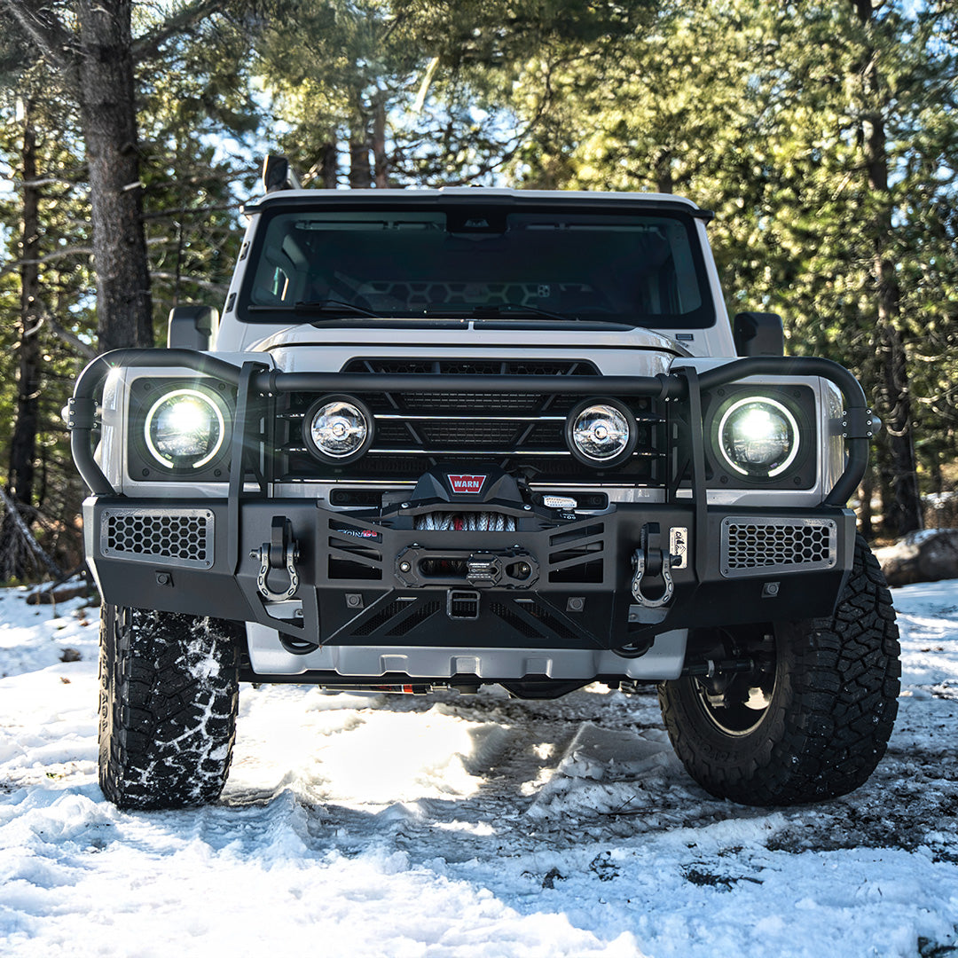 Front view of an SUV with a black bull bar and winch in snow