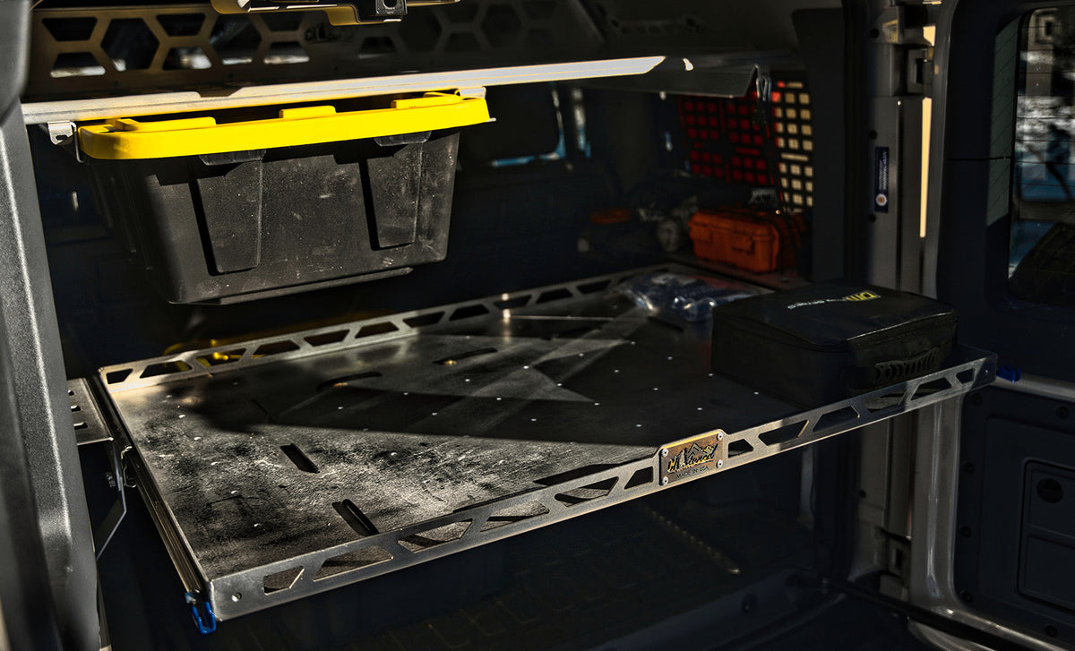 Slide-out shelf holding a yellow and black storage bin in a cargo area