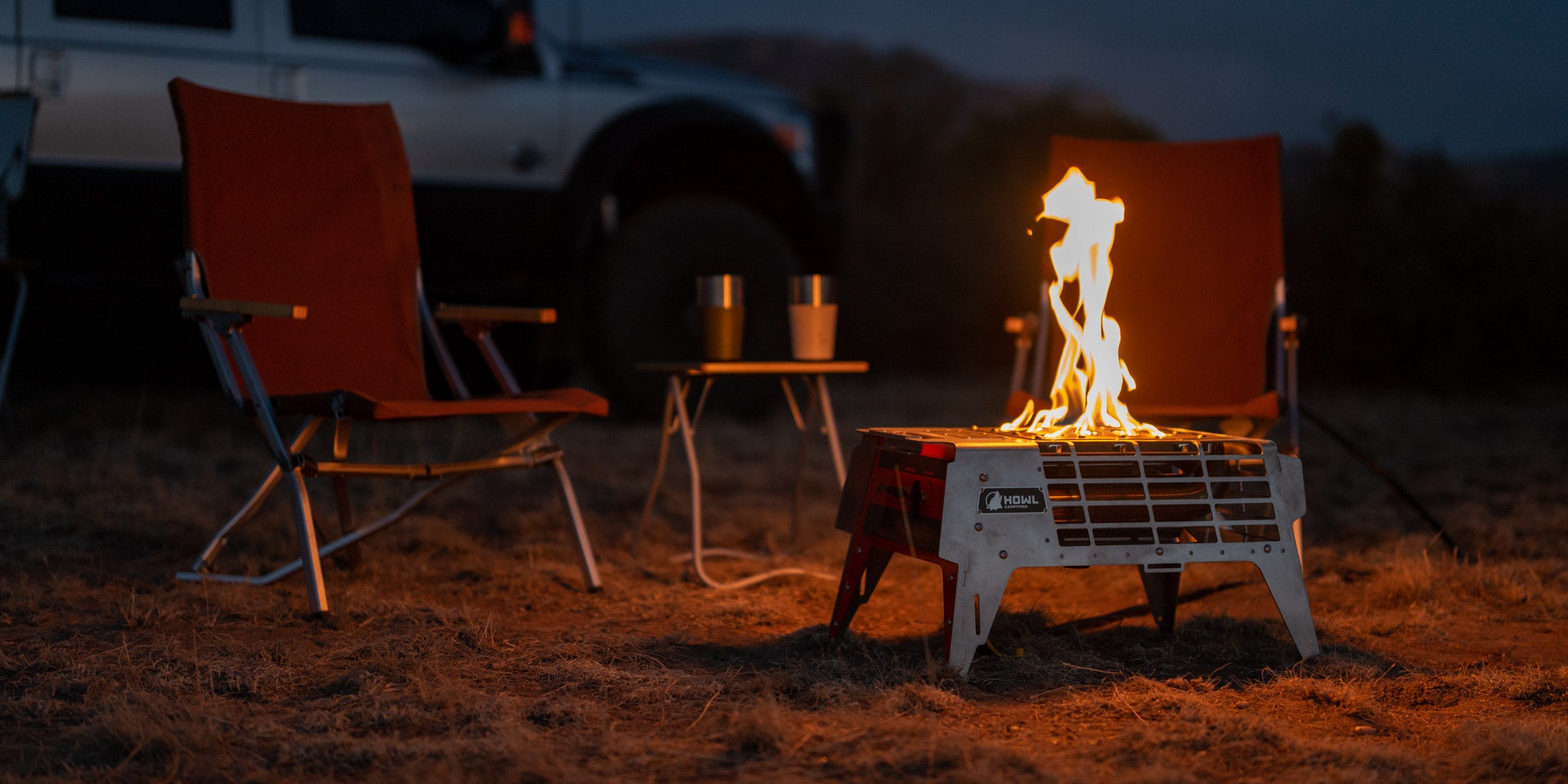 Howl R4 Portable Propane Campfire surrounded by Snow Peak camp chairs and earthroamer