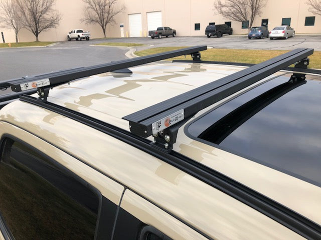 Eezi-Awn K9 load bars with Eezi-Awn badge on a vehicle roof