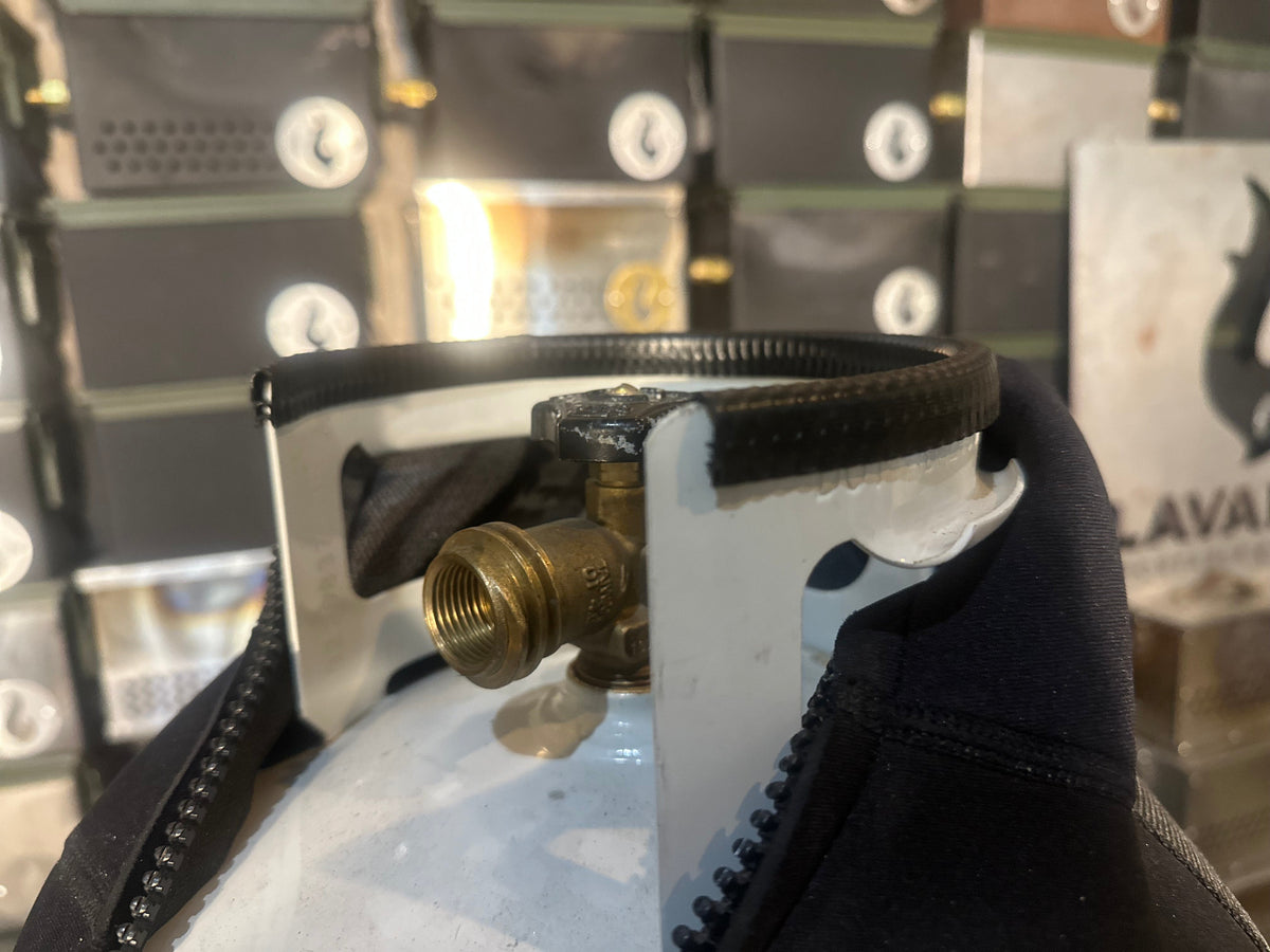 Close-up of a propane tank valve fitted with a bracket clamp, tank wrapped in a navy LAVABOX tank top cover