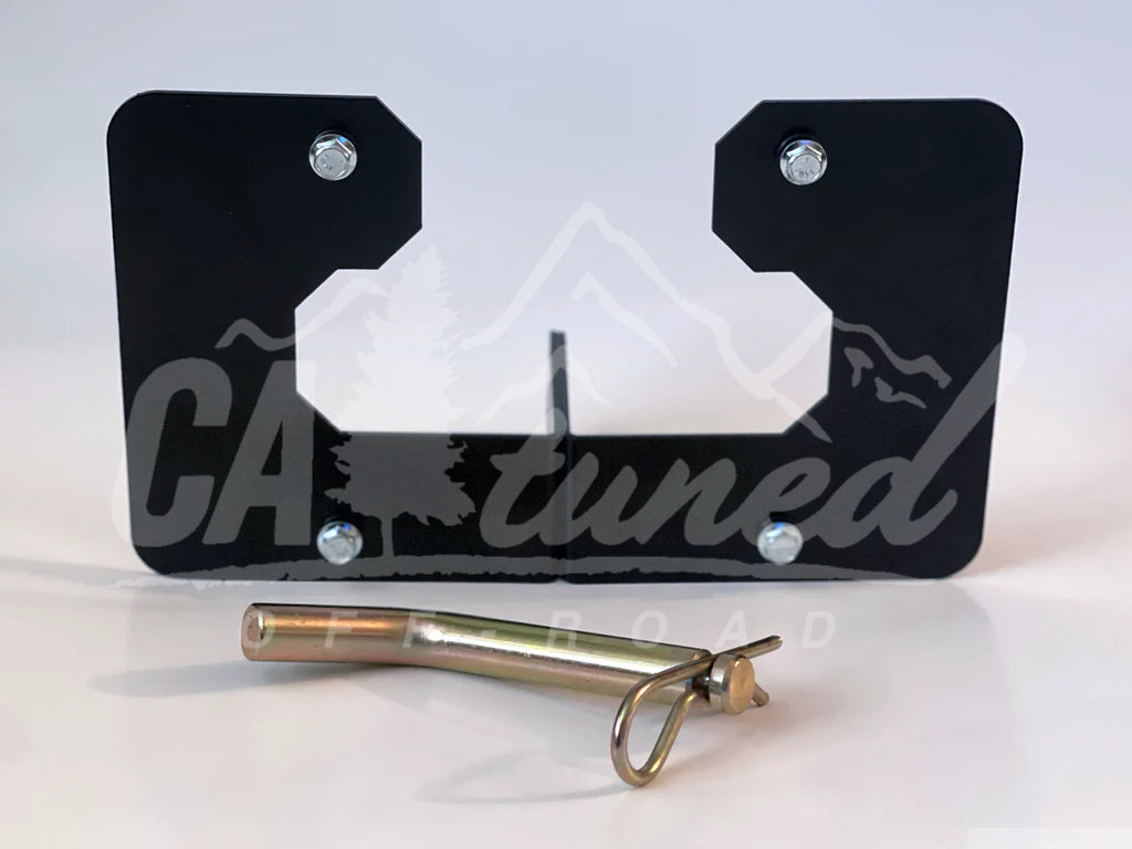 Black plate bracket with a cutout and a gold hitch pin on a white background