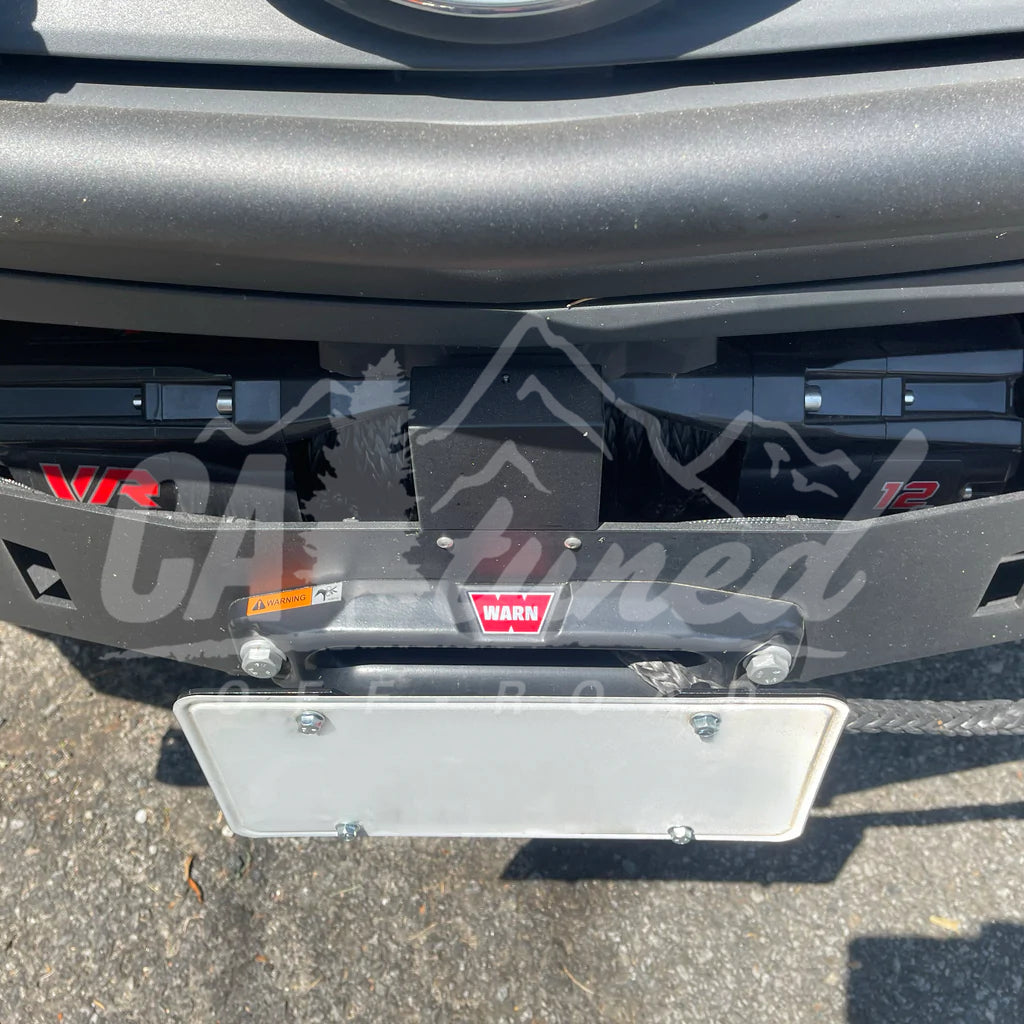 License plate mounted on the relocation bracket inside a hitch receiver below a bumper