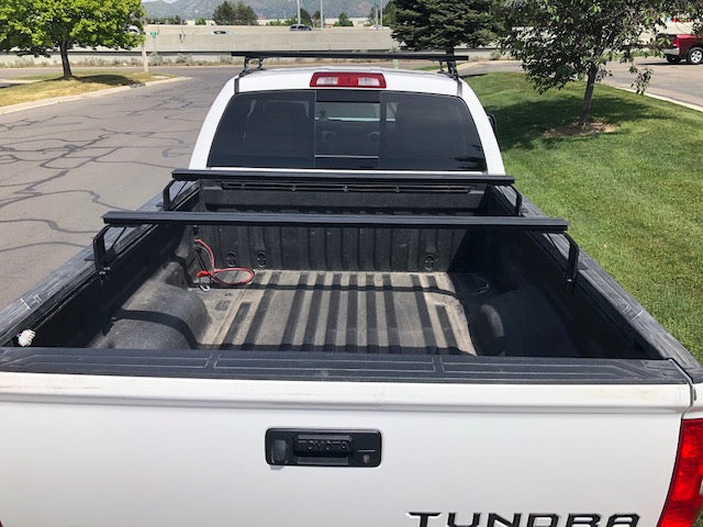 K9 bed rail load bars across a pickup bed, rear view