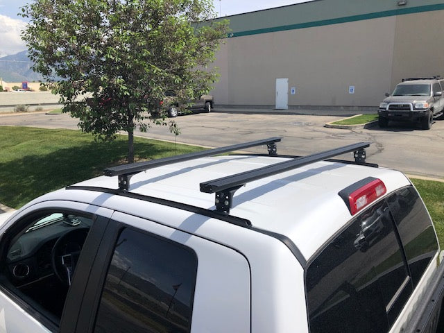 Eezi-Awn K9 load bars on a white crew cab roof, rear view