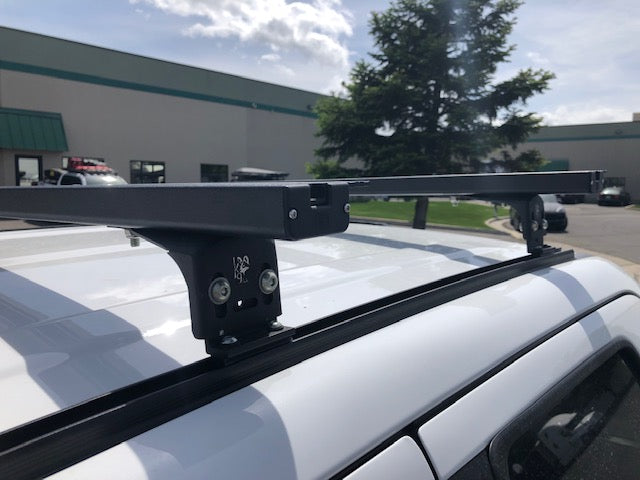 Close-up of K9 load bar mounting foot on a white vehicle roof