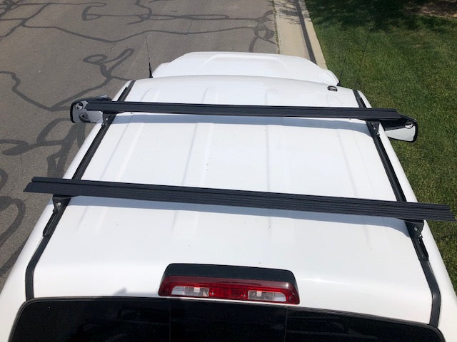 Eezi-Awn K9 load bars on a white vehicle roof, overhead view