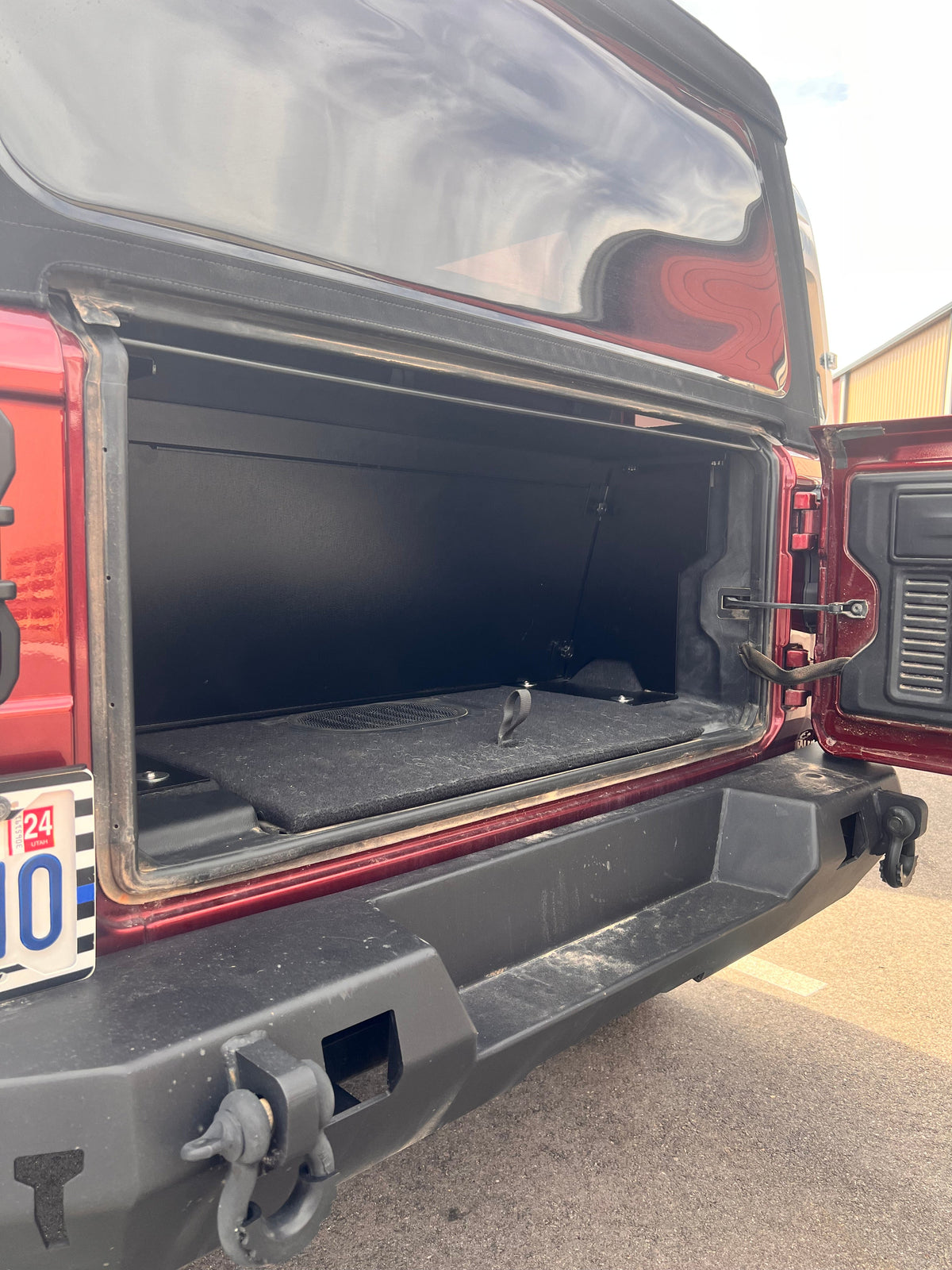 Red Jeep JL 2-door with the tailgate open showing the Locker behind the rear seat