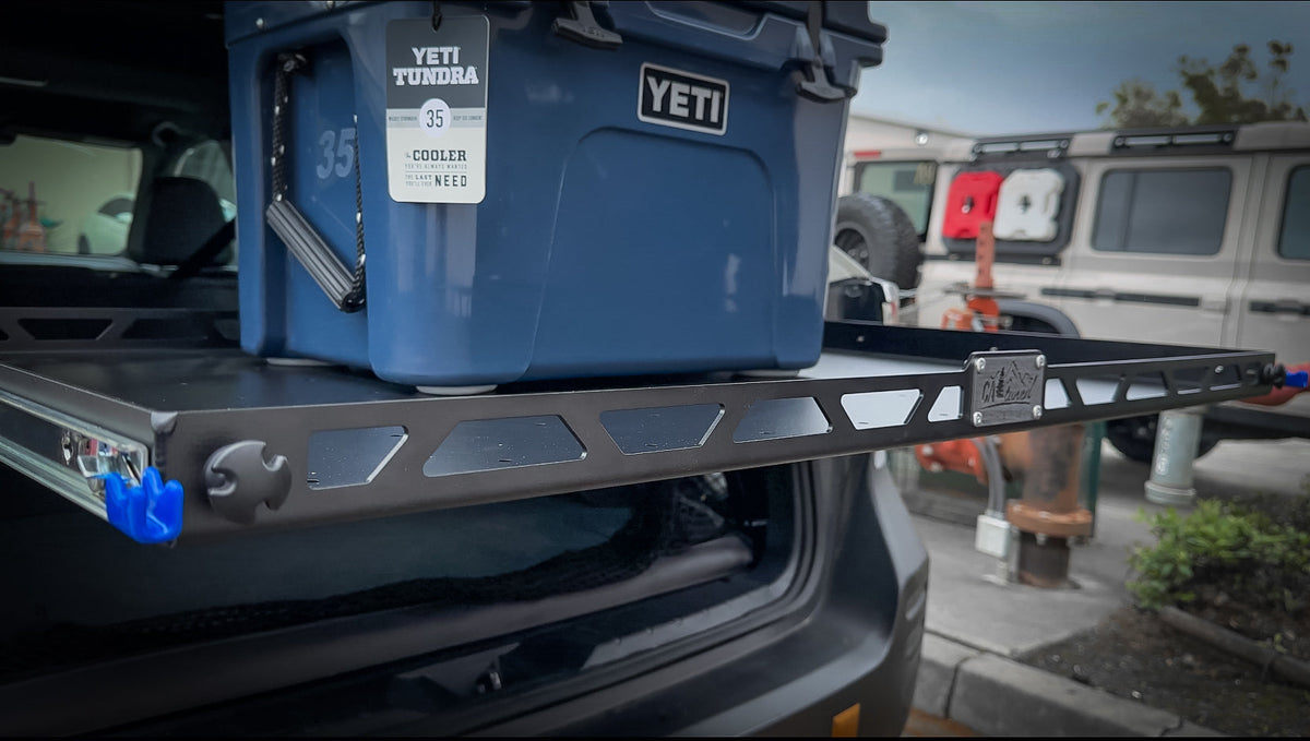 Cargo shelf slid out of the vehicle with a blue cooler on top