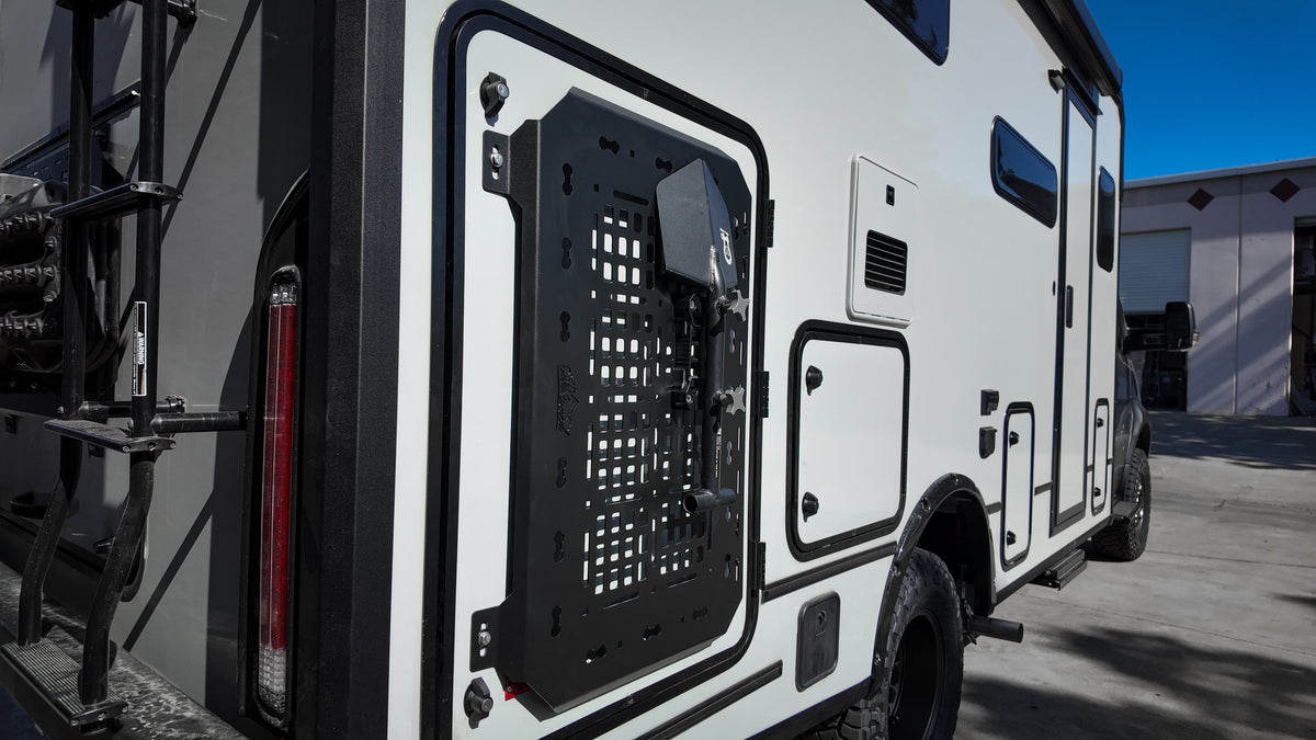 Black MOLLE panel on the door of a van beside a tail light