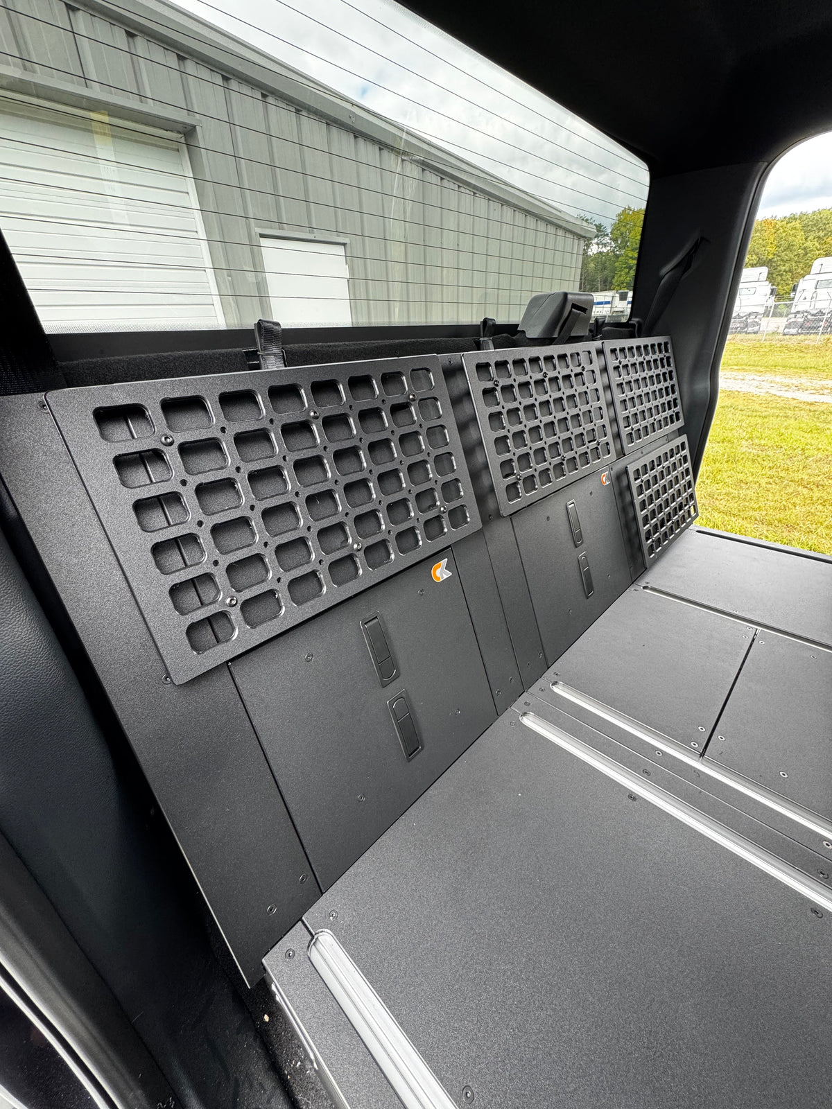 CargoKits MOLLE side wall panels installed in a Ford F-Series SuperCrew, view from the rear seat looking toward the tailgate