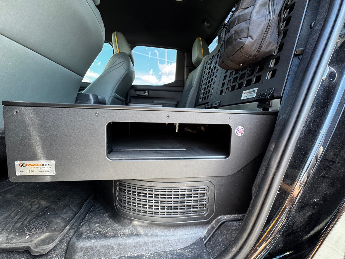 Close-up of the CargoKits seat delete platform's drawer-style front with its open storage cutout and CargoKits serial plate