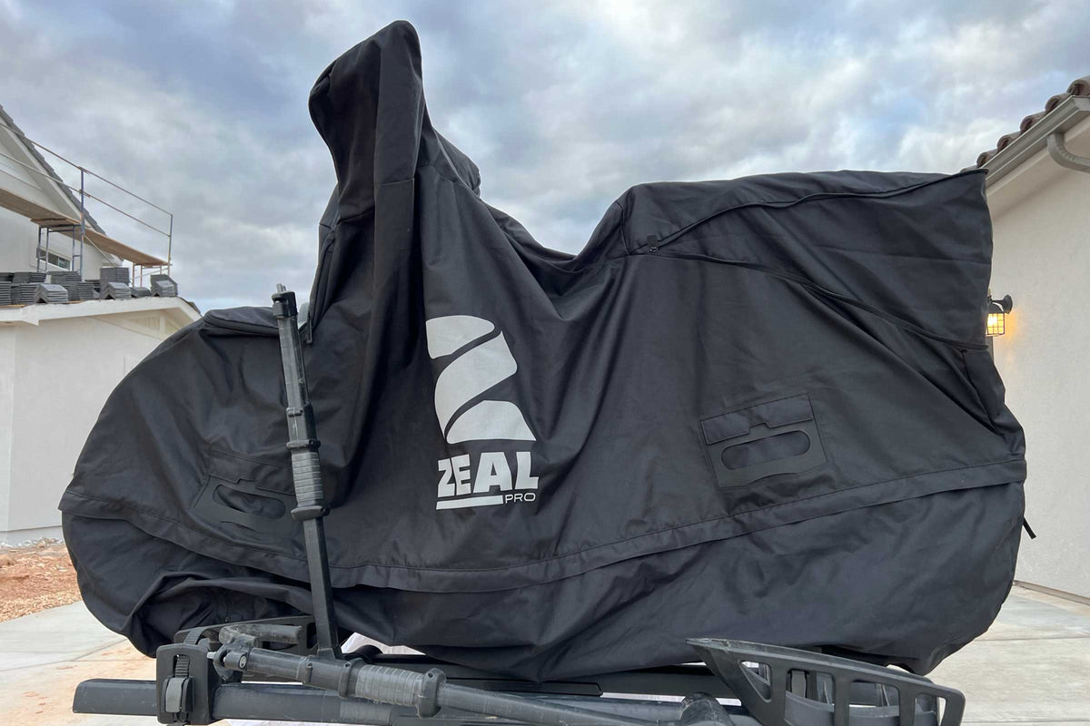 ZEAL Pro e-bike cover fully closed over a step-through e-bike on a tray hitch rack in a driveway