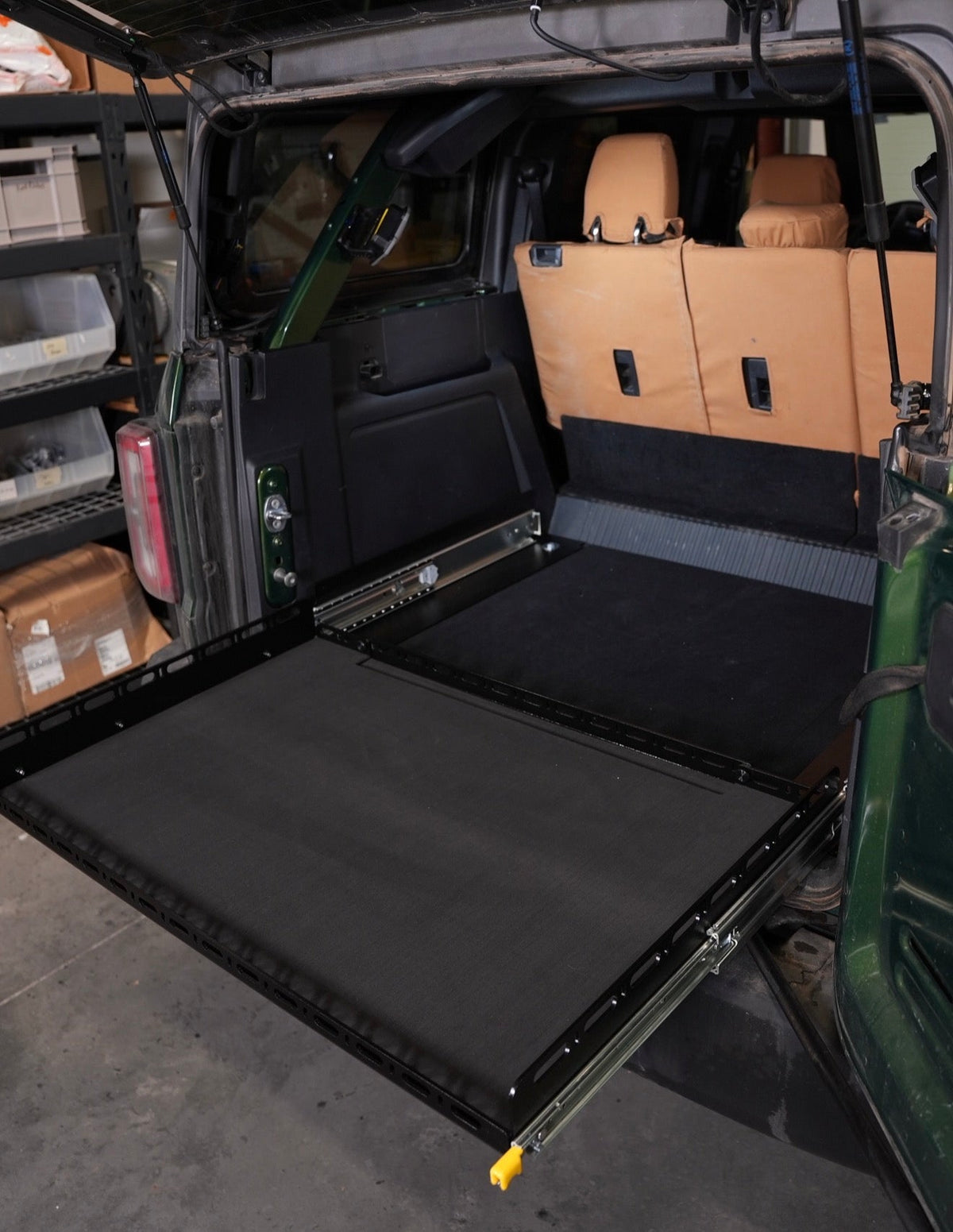 Bronco Slide Floor 2.0 extended out the back of a green Bronco 4-door