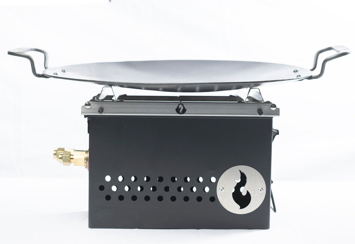 Black steel firebox fitted with a round steel griddle disc on top, studio shot on white background