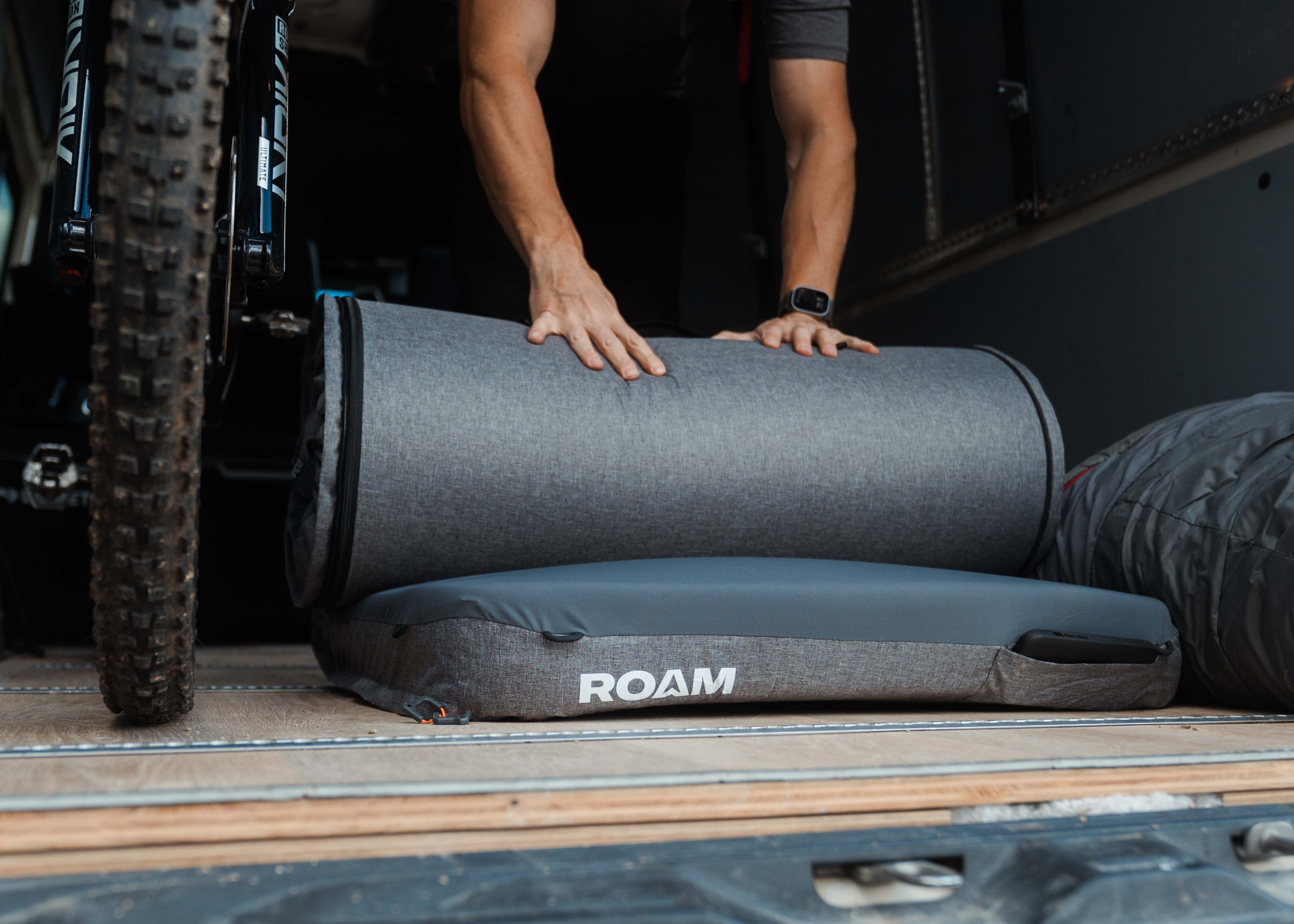 Man rolling up roam mattress
