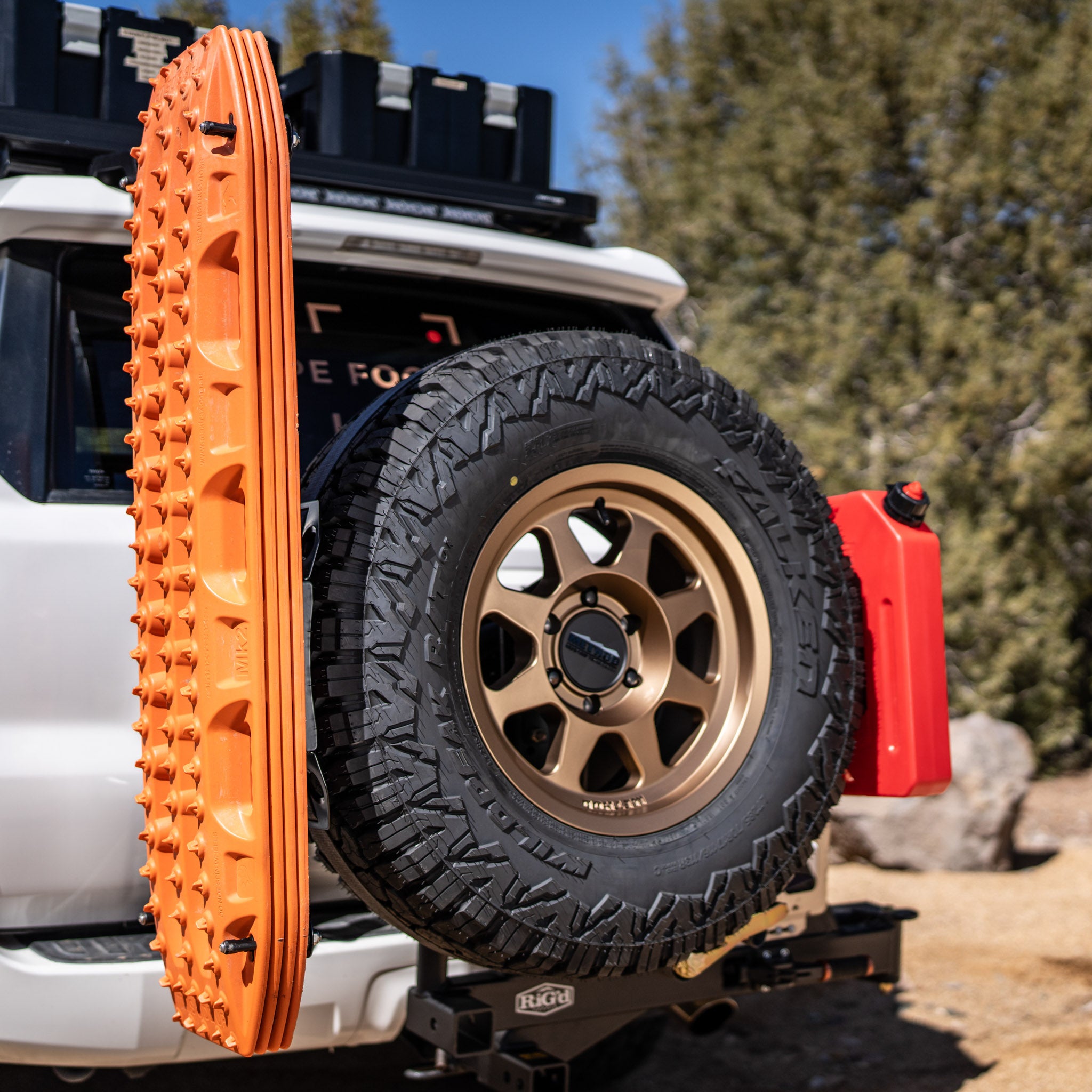 The Overland Kitted Spare Tire Mount featuring 4 orange maxtrax mounted and one red rotopax mounted.