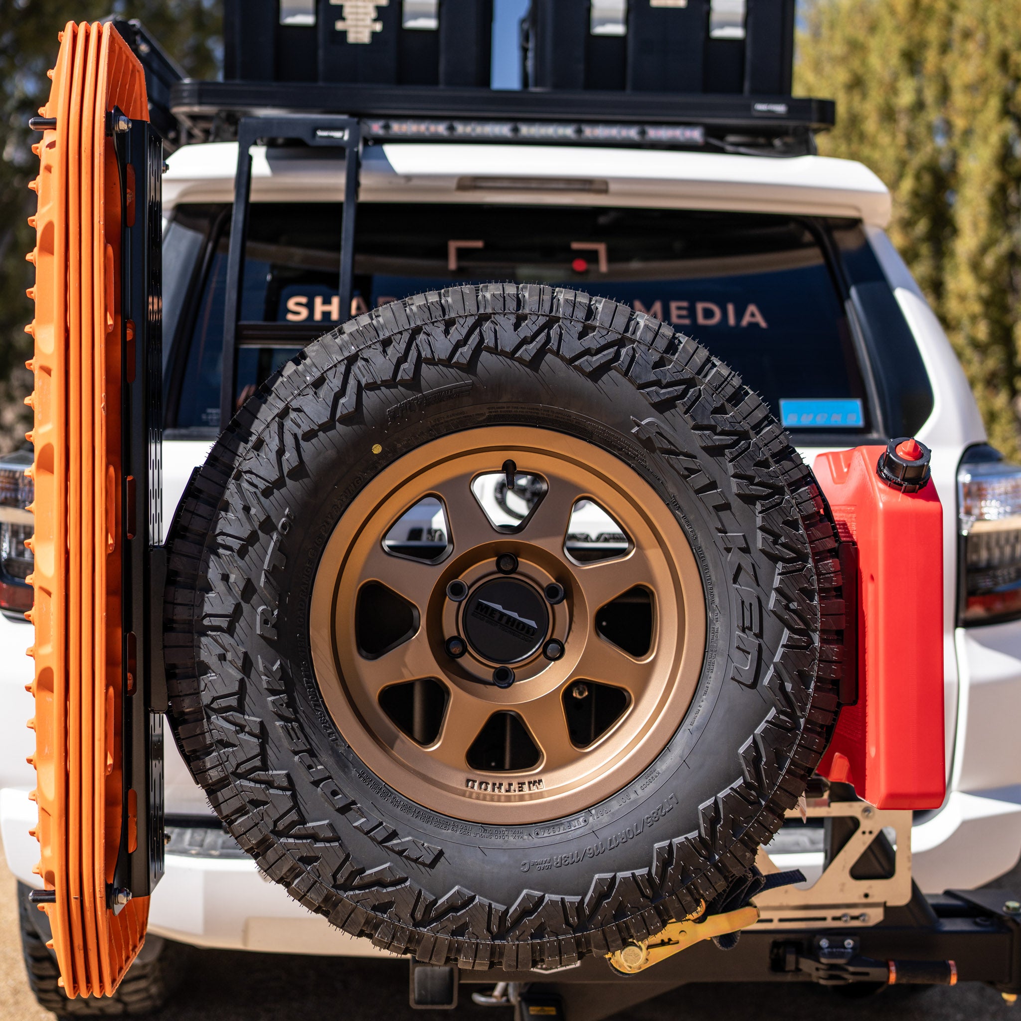 The Overland Kitted Spare Tire Mount featuring 4 orange maxtrax mounted and one red rotopax mounted.