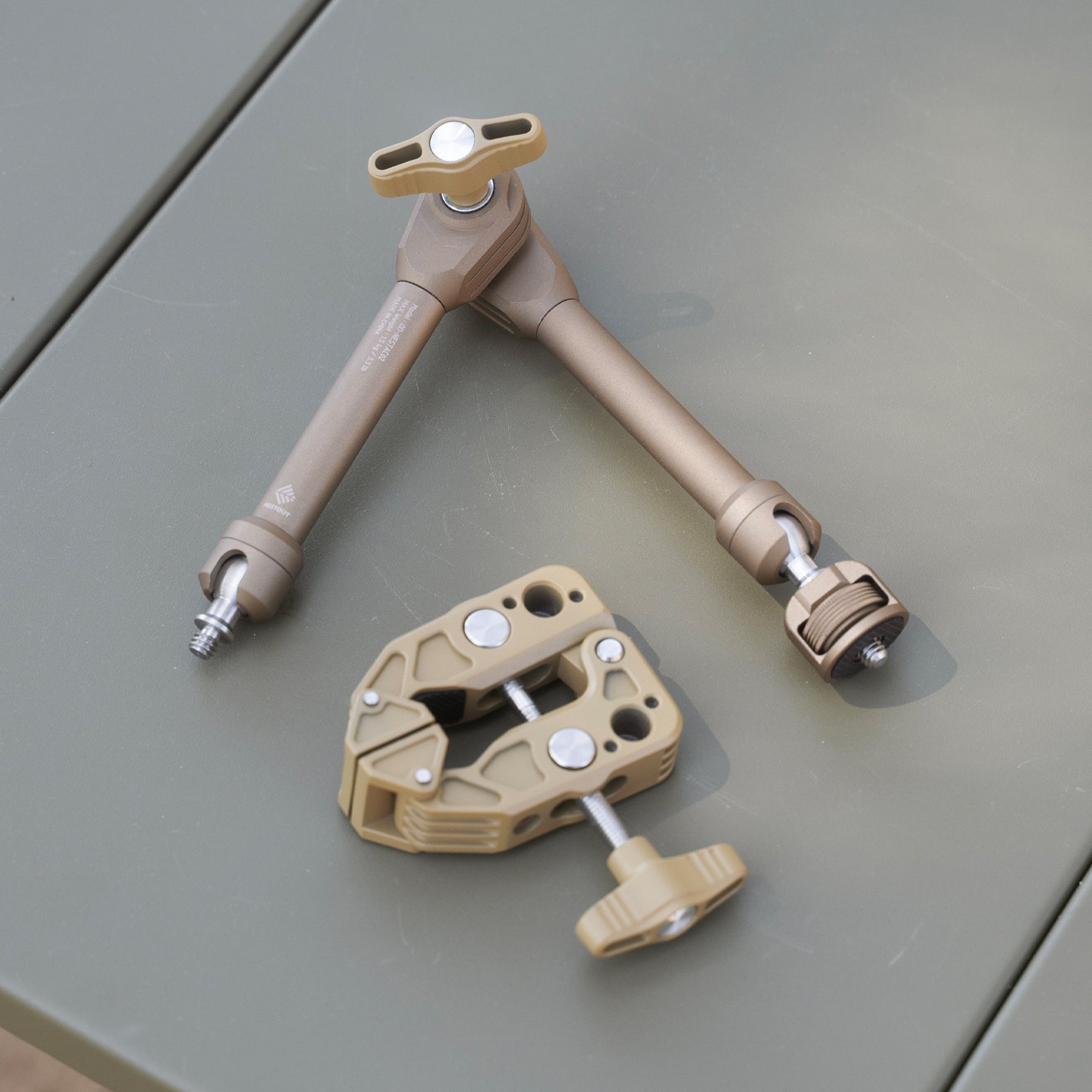 NESTOUT Clamp Arm disassembled into its clamp and arm pieces, beige colorway, on a tabletop