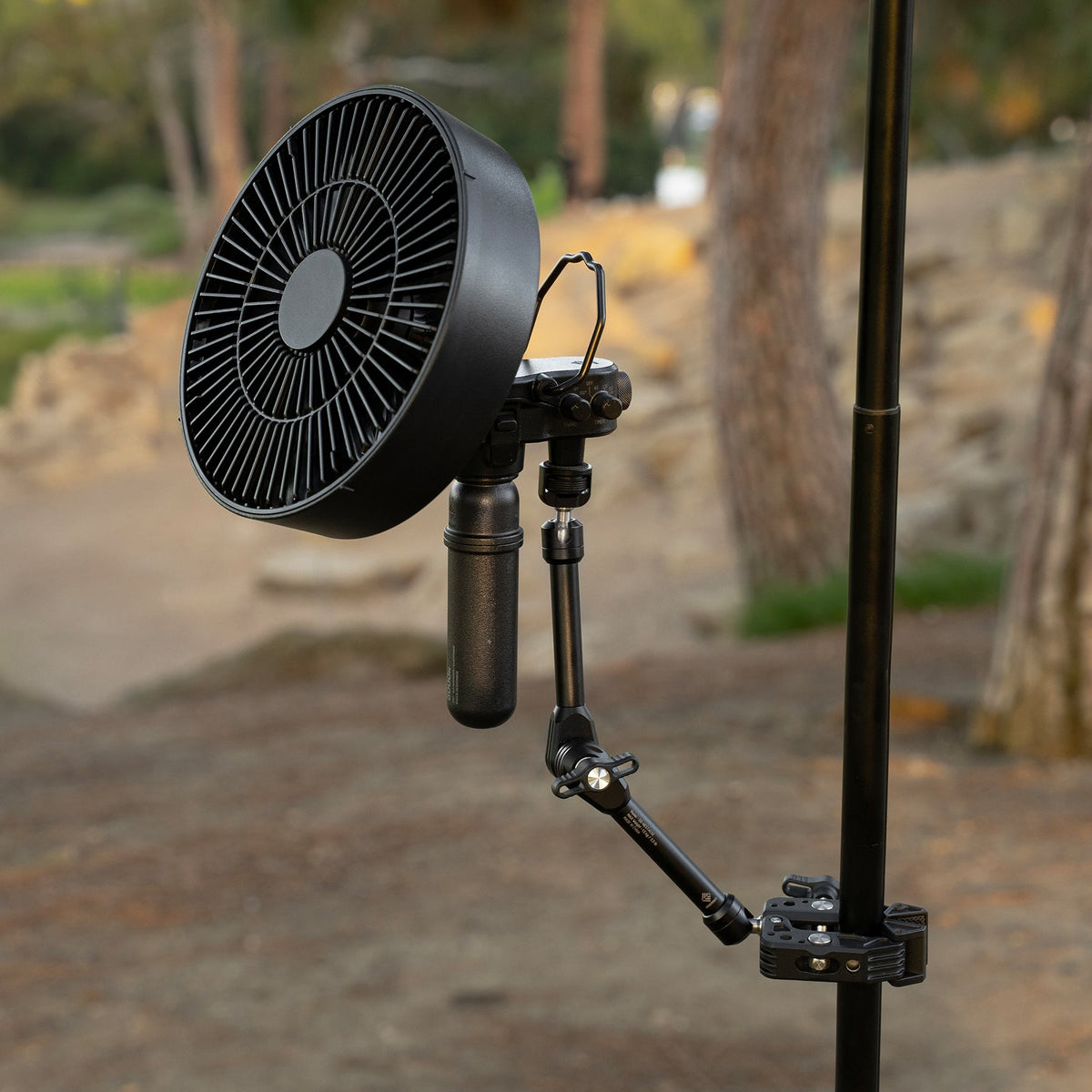 NESTOUT Clamp Arm holding the FAN-1 fan, clamped to a ladder rail outdoors