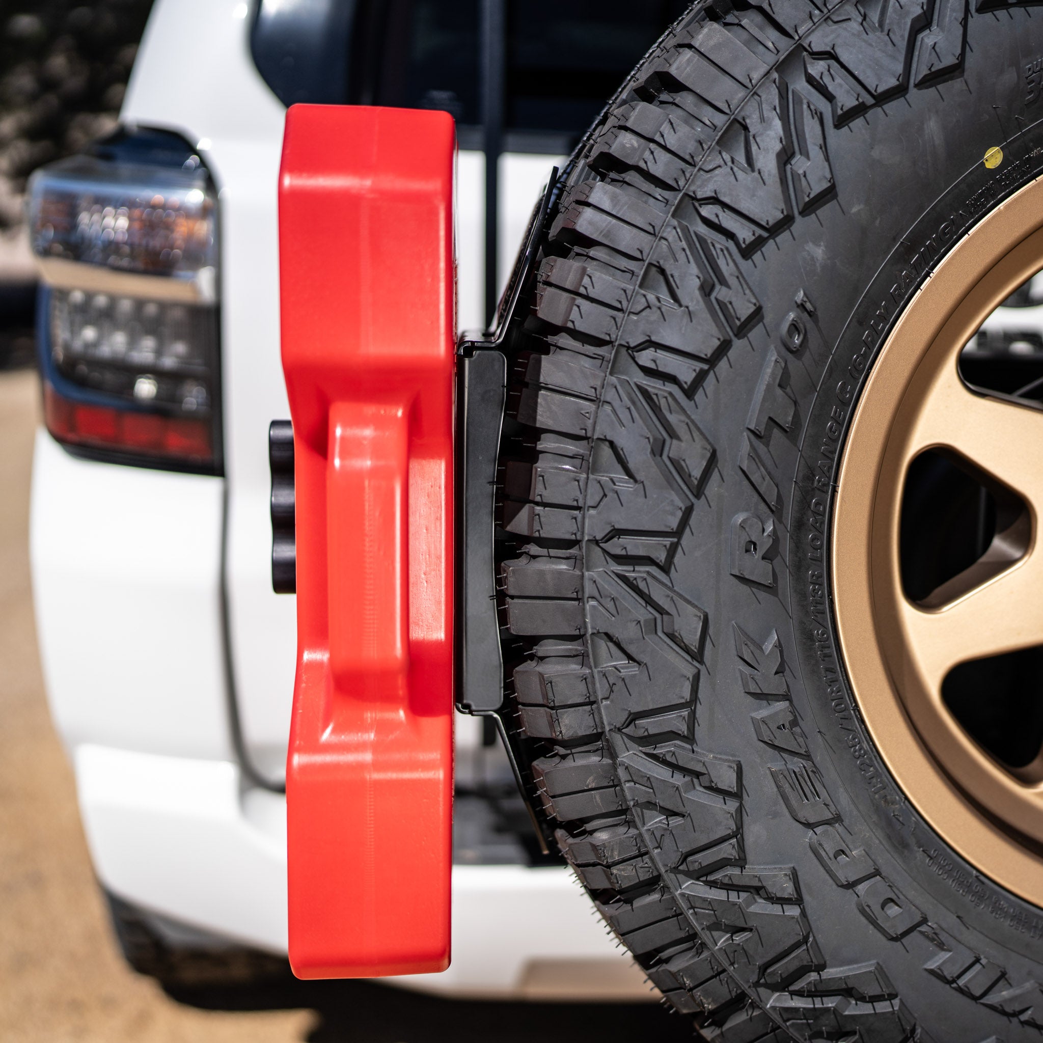 A red rotopax mounted on the overland kitted spare tire mount