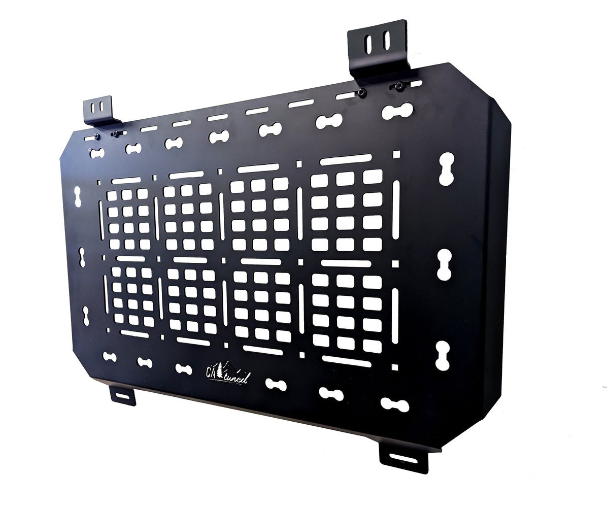 Black MOLLE panel with mounting tabs on a white background, angled view