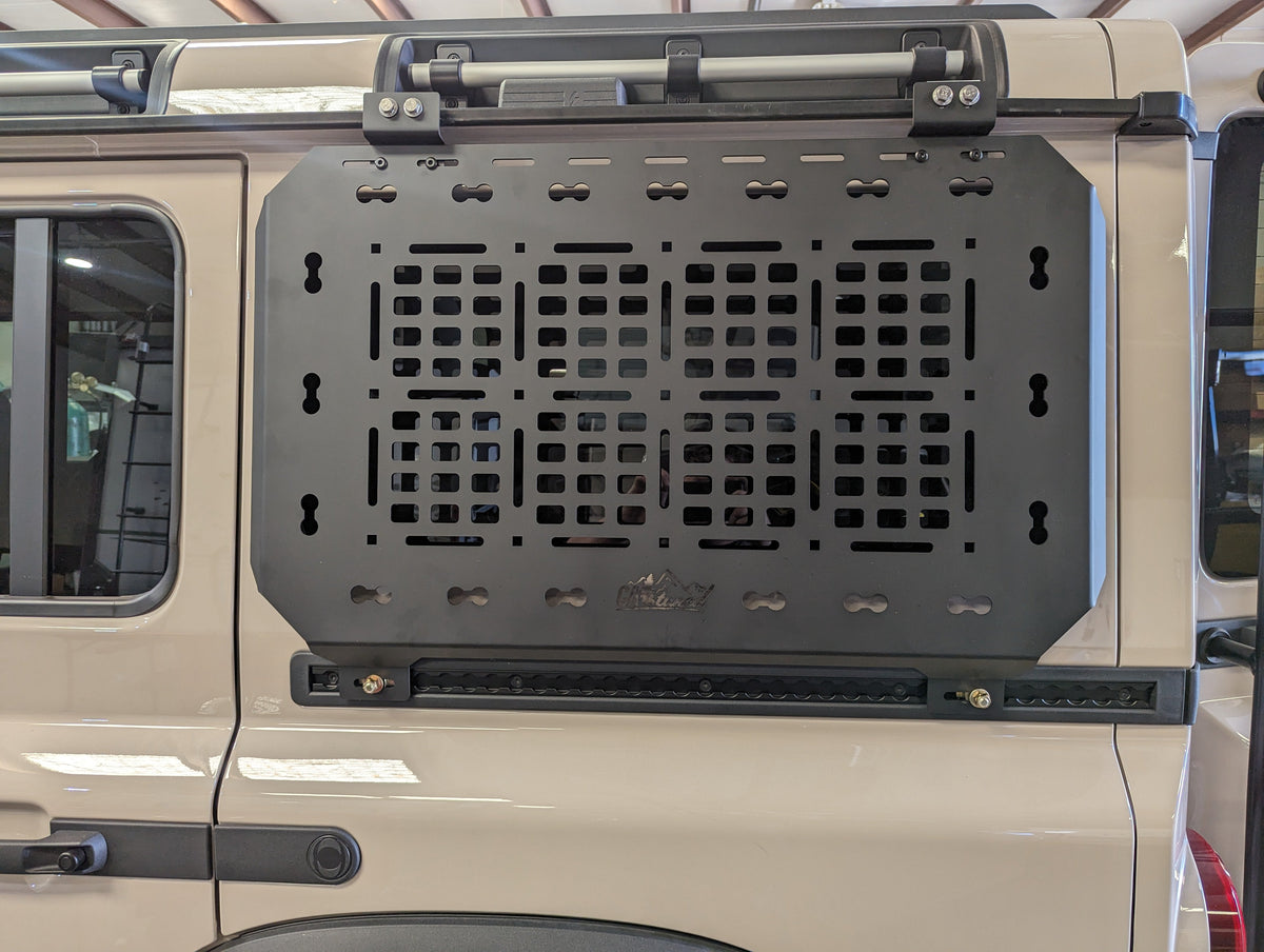Empty black MOLLE panel installed on the side of an SUV below a roof rack