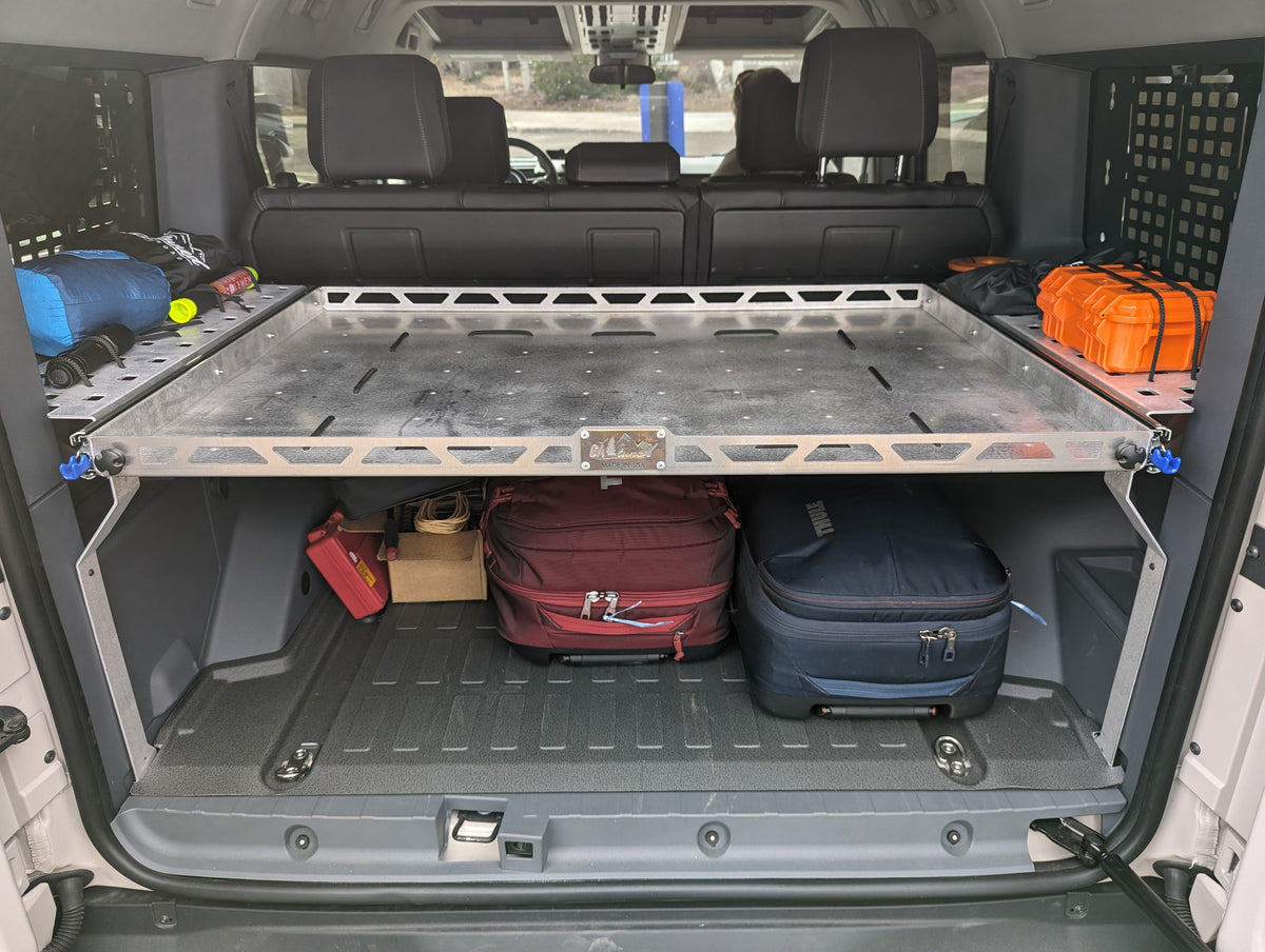 Metal shelf in the cargo area of an SUV loaded with bags and gear