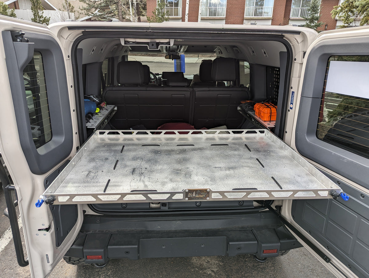 Shelf slid out toward the open rear door with luggage on the lower level