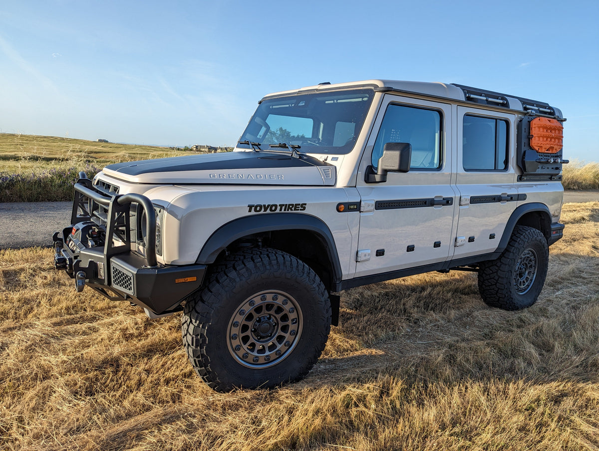 Silver SUV with a bull bar parked in a field