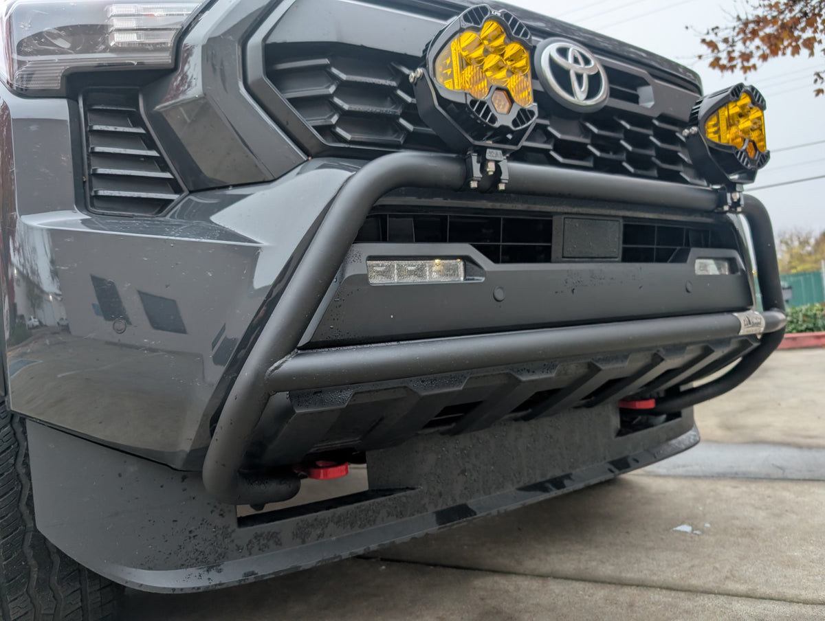 Close view of the black brush bar and amber light pod on the front of a Toyota truck