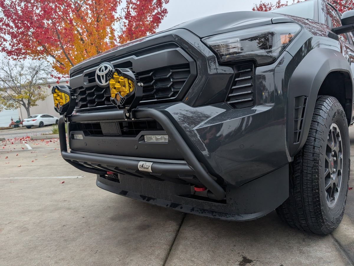 Front three-quarter view of a gray Toyota truck with a brush bar and amber lights