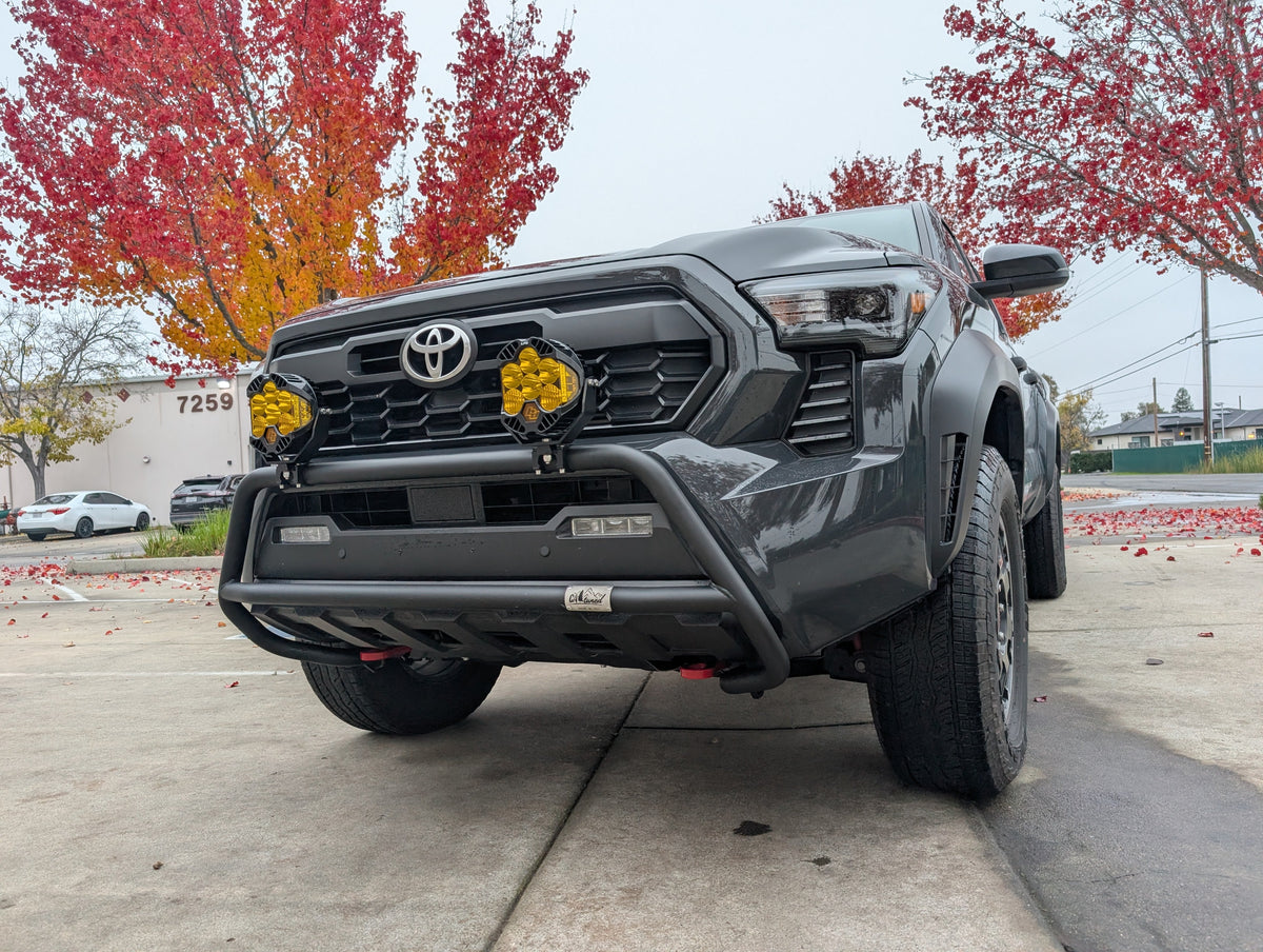 Front view of a gray Toyota truck with a brush bar and amber light pods