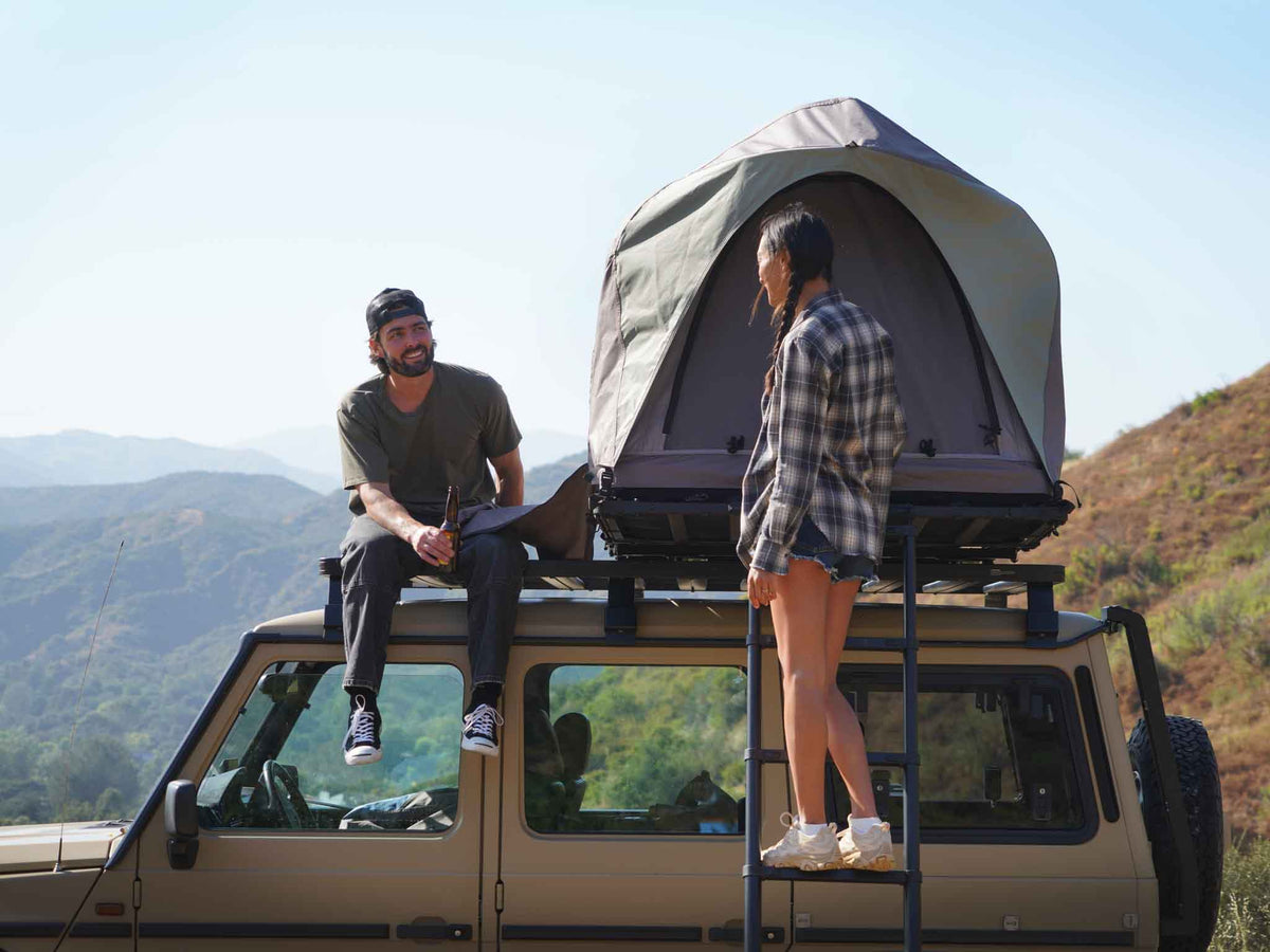 C6 Rev Rooftop Tent X (Element) – two people on a vehicle roof beside the tent