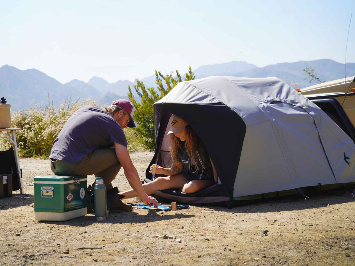 C6 Rev Tent (HellaStorm) – camp scene with the tent and people