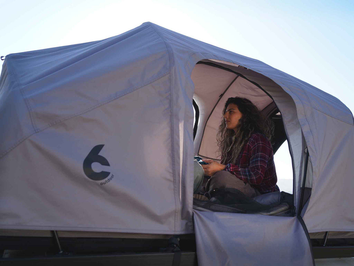C6 Rev Rack Tent (HellaStorm) – person sitting in the tent doorway